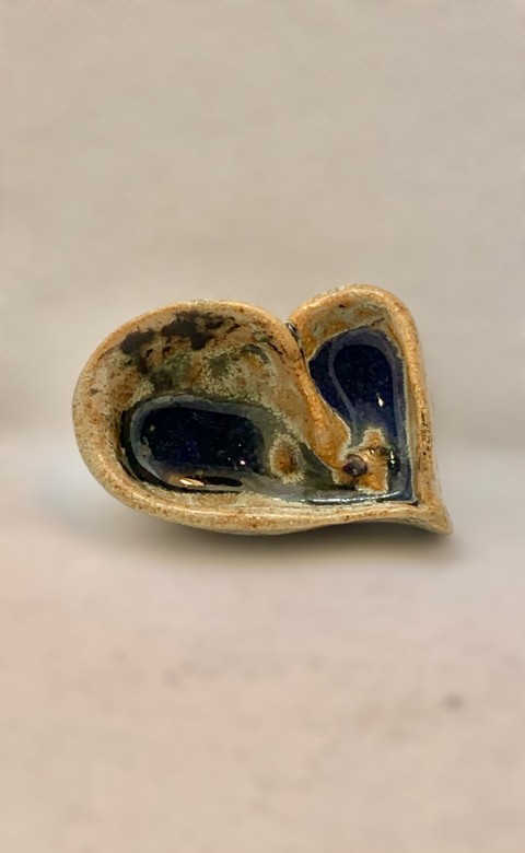 Corazón beige anaranjado con interior azul en el fondo. Exterior manchado