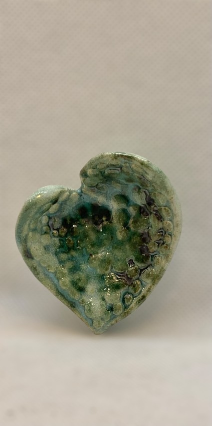 Corazón verde, blanco celeste, con textura de pelotitas en el interior 