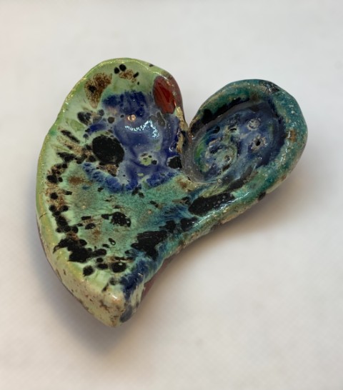 Corazón verde y azul con manchas negras y rojas, varios cristales