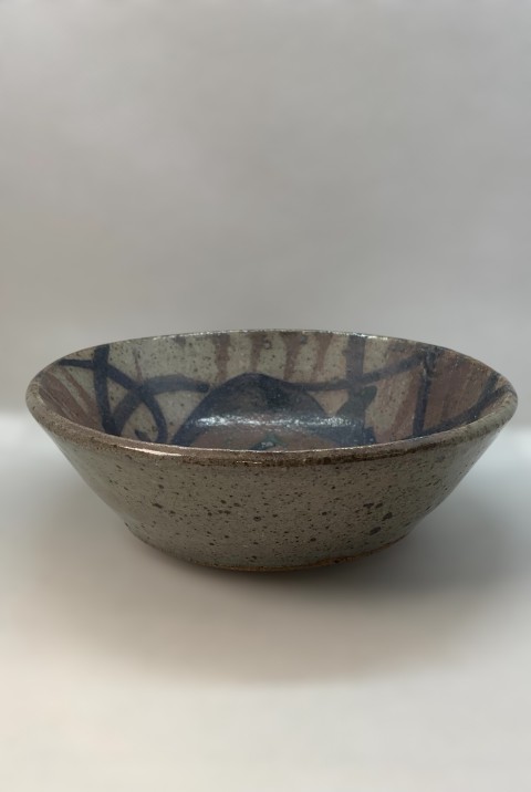 Plato hondo pequeño gris con dibujos cobalto, cobre, café. Manchas oscuras