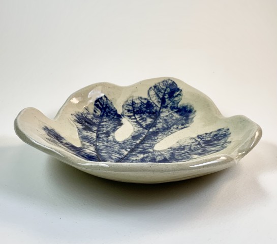 Plato blanco con hoja impresa cobalto. Cortada con forma de hoja