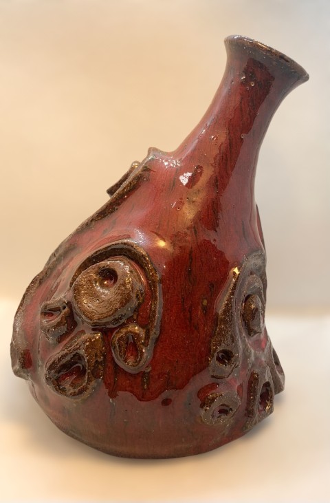 Vasija torneada y esculpida. Cuello y apertura delgados. Rojo cadmio. Pomaire