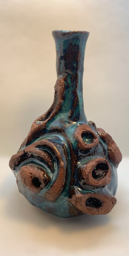 Vasija torneada y esculpida. Cuello y apertura delgados. Celeste turquesa. Pomaire