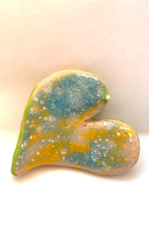 Corazón pequeño celeste con manchas blancas, amarillo y verde al reverso