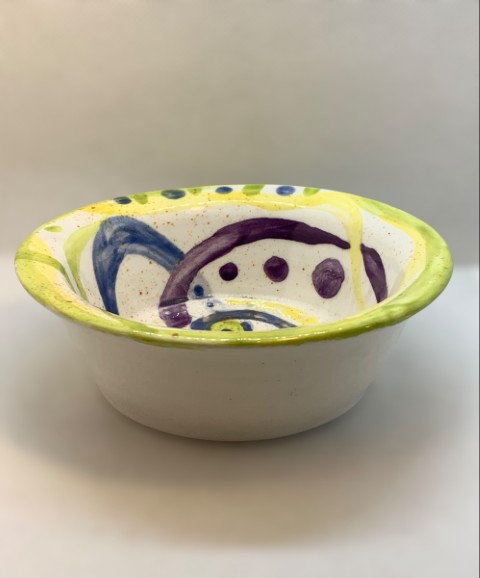 Pocillo blanco con dibujos verdes, azul, morado y amarillo. Exterior blanco