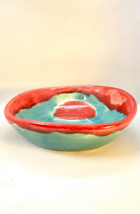 Plato turquesa y rojo brillantes, forma irregular, borde ligeramente curvo