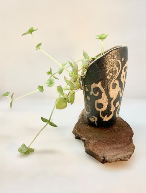 Pasta Chamiza. Macetero alargado con engobe oscuro y esgrafiado. Madera y planta