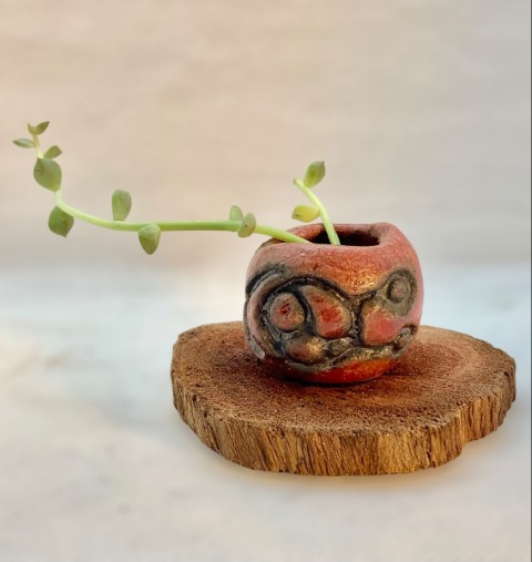 Pasta Chamiza. Un mini cuenquito rojo con bajorelieve óxido oscuro. Madera y planta