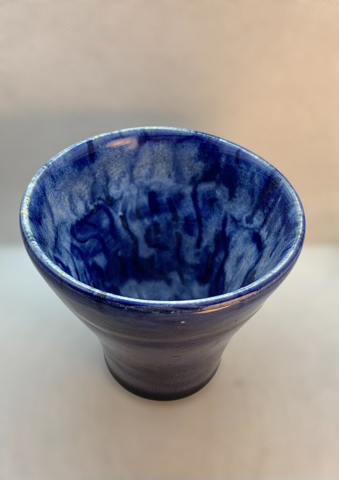 Vasija azul por fuera, blanca con líneas azules por dentro. Ancha arriba