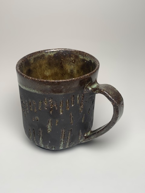 Taza pasta negra con esmalte celeste, bajorelieves verticales con celeste. Pasta expuesta