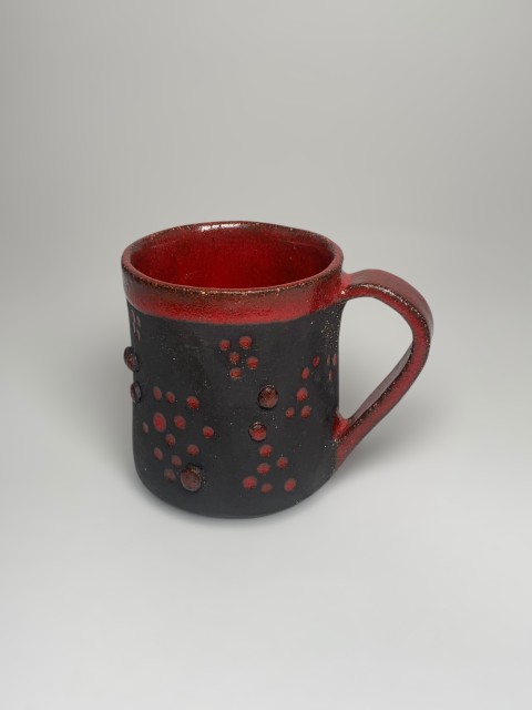 Taza pasta negra con interior y bajorelieves rojos, exterior pasta expuesta