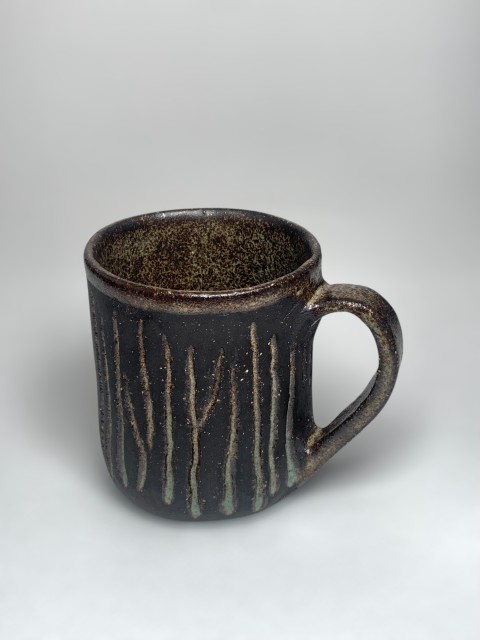 Taza pasta negra con verde musgo interior y bajorelieve, líneas verticales. Pasta expuesta