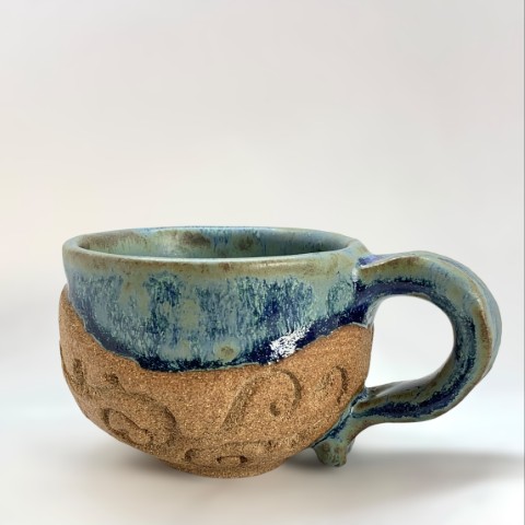 Taza pasta café interior y borde azul piedra. Labrado exterior pasta expuesta