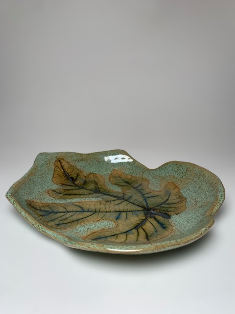 Bandeja forma de hoja fondo verde manzana con hoja higuera cobre. Pasta café.