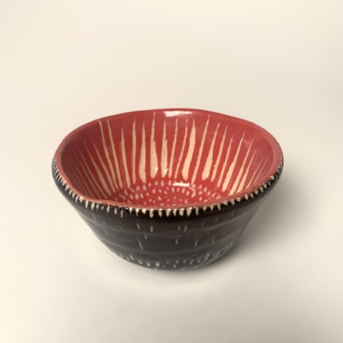 Pocillo torneado con engobe rojo interior y exterior negro. Flor en interior