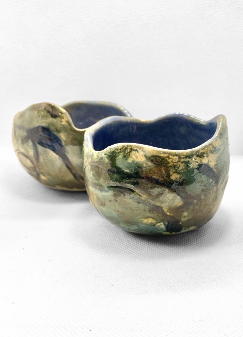 Cuenco esférico borde irregular. Interior cobalto exterior cobre dibujos