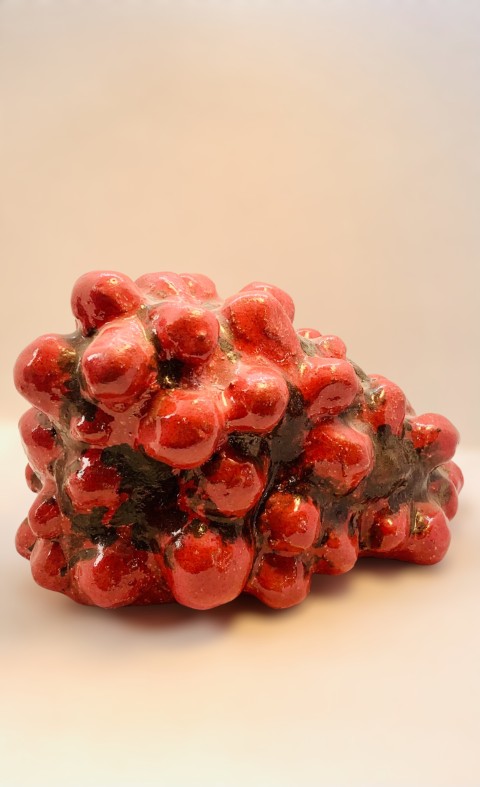 Escultura roja con pelotas. Manchas negras