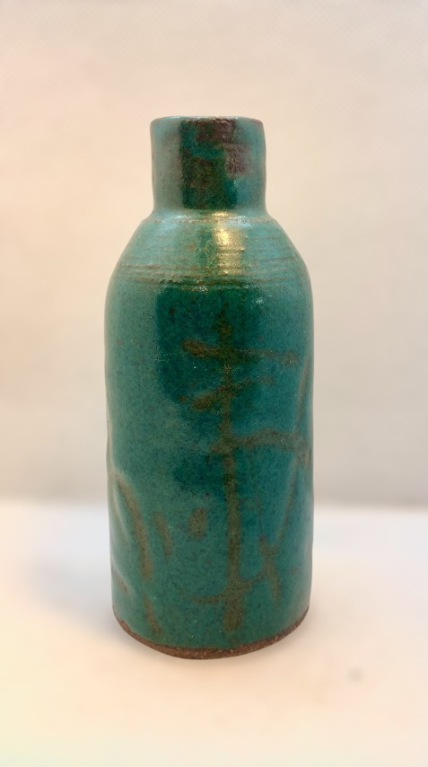 Botella verde con gráfica café. Boca pequeña