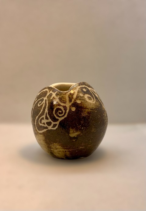 Cuenco esférico apertura estrecha. Engobe fierro con diseños bajorrelieve blanco