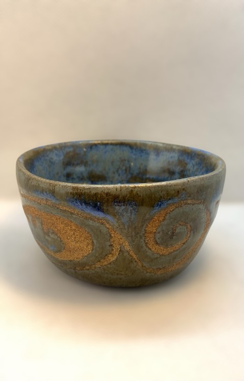 Pocillo azul con manchas cafés. Exterior azul con dibujos cafés de la pasta con cera