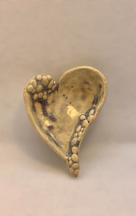 Corazón pequeño amarillo muy pálido con pelotitas en borde. Manchas moradas